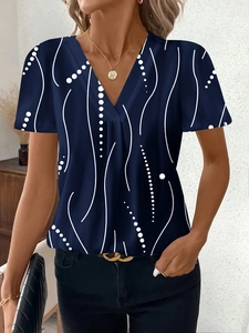 Dettaglio dello scollo a V sulla maglietta blu scuro stampata con motivi bianchi astratti
