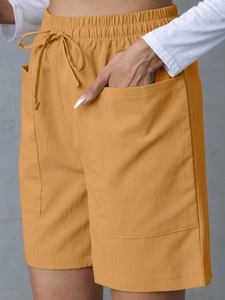 Detailed macro view of ginger yellow linen shorts with drawstring waist and side pockets