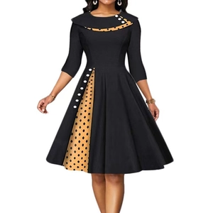 Dettaglio di un abito nero vintage con patchwork a pois e grandi bottoni bianchi
