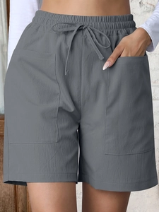 Detail of high waist grey linen shorts featuring elastic drawstring and large front pockets