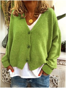 Detail eines übergroßen Strickcardigans in Salbeigrün mit V-Ausschnitt und Knöpfen