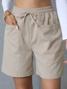 Detail of linen casual shorts showing elastic drawstring waist and large side pockets
