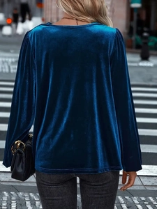 Rear view of long sleeve dark blue velvet top with puff shoulder details on street