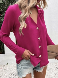 Detail of bright rose red long sleeve shirt with brown buttons and elegant V-neck design
