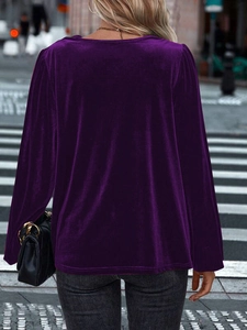 Rear view of deep purple velvet long sleeve top with elegant puffed sleeves on street