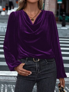 Detail of purple velvet long sleeve top with elegant draped neck and shiny fabric texture