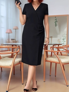 Detail view of the elegant V-neckline and ruched side draping on a black midi dress