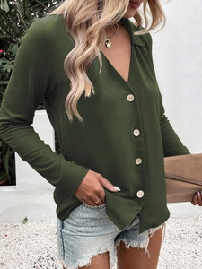 Close-up of elegant dark green long-sleeve blouse with V-neck and decorative buttons