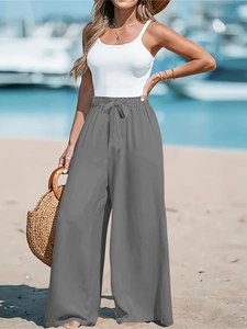 Dettaglio dei pantaloni grigi a vita alta e gamba larga con coulisse elastica in vita