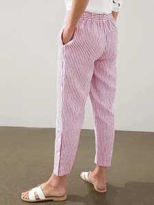 Detail of red and white striped pants featuring unique side button hem and elastic waist
