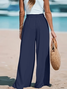 Vista posteriore di pantaloni a gamba larga a vita alta su uno sfondo di spiaggia