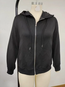 Détail d'un sweat noir à capuche zippé avec texture gaufrée géométrique et cordon de serrage