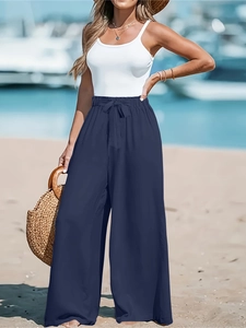 Dettaglio dei pantaloni larghi blu scuro da donna con vita elasticizzata, coulisse e trama a righe