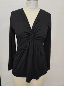 Detail of front twist knot and deep V-neck on black long sleeve slim fit shirt