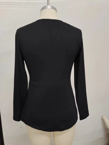Detail view of the back seams and slim waist fit of this long-sleeve black top