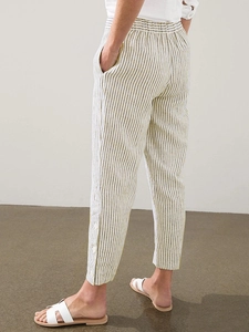 Detail of striped linen pants showing the elastic waist and buttoned hem decoration