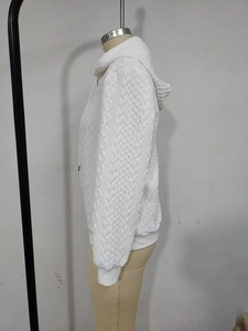 Detail of white cable knit texture on long sleeve hooded jacket with ribbed cuffs