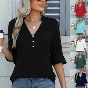 Dettaglio della camicetta in chiffon con scollo a V, bottoni di perle e polsini a volant