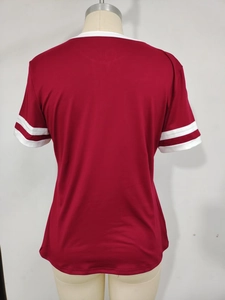 Detail view of burgundy short-sleeve top showing white round neck and striped sleeve cuffs