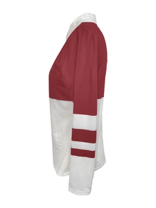 Detail of red and white contrast long sleeve top featuring striped cuffs and polo collar