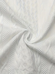 Macro shot of white knitted jacquard fabric showing soft texture and premium 3D weave detail