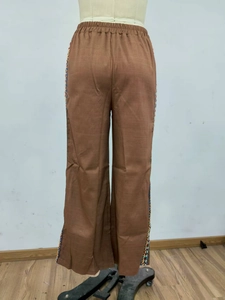 Detailansicht brauner Weitbein-Hose mit hoher Taille und ethnischer Stickerei am Saum