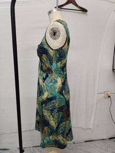 Detail of a sleeveless summer dress with tropical leaf print and elegant knot design