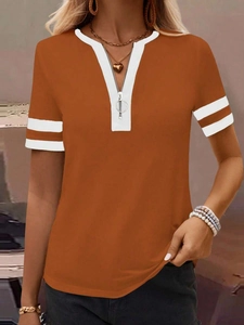 Detail of warm orange V-neck t-shirt with silver zipper and white stripe cuffs