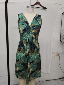 Detail view of tropical palm print dress featuring a twist knot waist and deep V-neckline