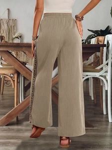 Detail einer hoch taillierten Leinenhose mit böhmischem Stickband an der Seite in Khaki