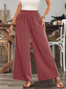 Details des hohen elastischen Bundes und der ethnischen Borte an der rostroten Hose
