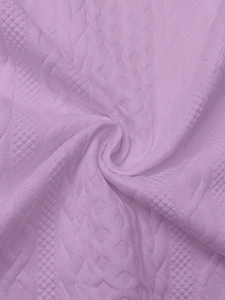 Détail de maille lavande montrant le motif torsadé complexe et la texture du tissu