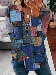 Gros plan du col en V zippé avec imprimé patchwork style denim et anneau métallique