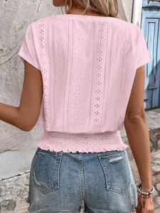 Back view of pink eyelet embroidered top featuring smocked waist and ruffle hem details