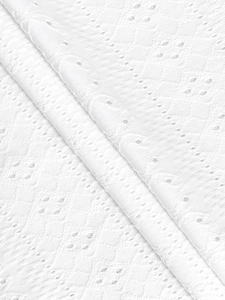 Detailed close-up showing white lace fabric with intricate geometric hollow patterns