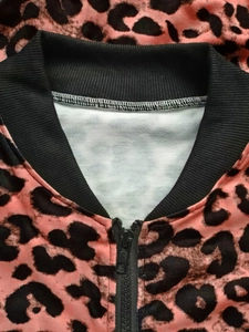 Detail of pink and black leopard print jacket with ribbed collar and black zipper