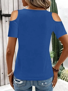 Back view of a royal blue cold shoulder T-shirt styled with denim in a summer setting