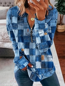 Détail du col en V avec fermeture éclair en métal sur un haut imprimé style denim