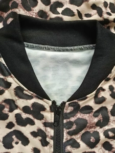 Close-up of leopard print jacket showing ribbed collar and high-quality zipper detail