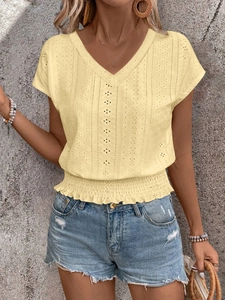 Detailed close-up of V-neck eyelet embroidery and smocked waist on yellow summer top