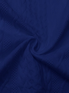 Macro shot of navy blue knit fabric with geometric texture and 3D diamond patterns
