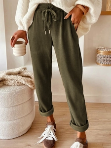 Detail of olive green ribbed wide-leg pants featuring drawstring waist and raw hem