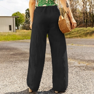 Outdoor view of women's black wide-leg trousers with high waist and relaxed cotton linen fit
