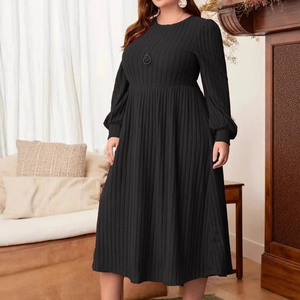 Close-up of black ribbed knit long sleeve dress with elegant textured fabric detail
