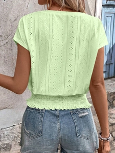 Detail of light green floral lace top with smocked waist and delicate embroidery texture