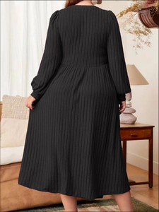 Detailed back view of a black ribbed knit plus size maxi dress in a cozy home setting