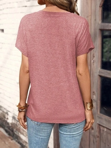 Rear view of a pink short sleeve t-shirt on a model with outdoor brick background