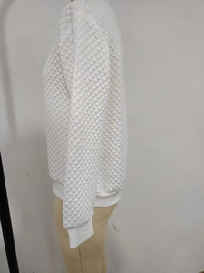 Detail of white quilted texture and ribbed cuffs on the long sleeve jacket for women