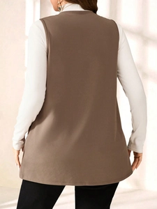 Rear view of a long coffee brown sleeveless vest over a white long sleeve top