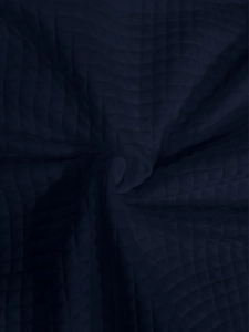 Macro shot of navy blue quilted knit fabric texture with geometric waffle pattern